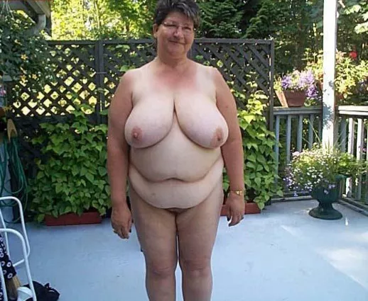 Busty mature nudist on her patio